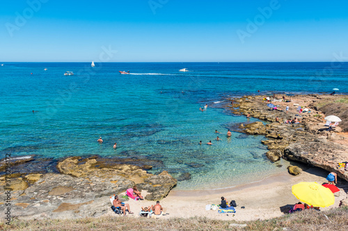 Wonderful Mediterranean coast beach in Puglia, South Italy, with bathers in crystal clear water