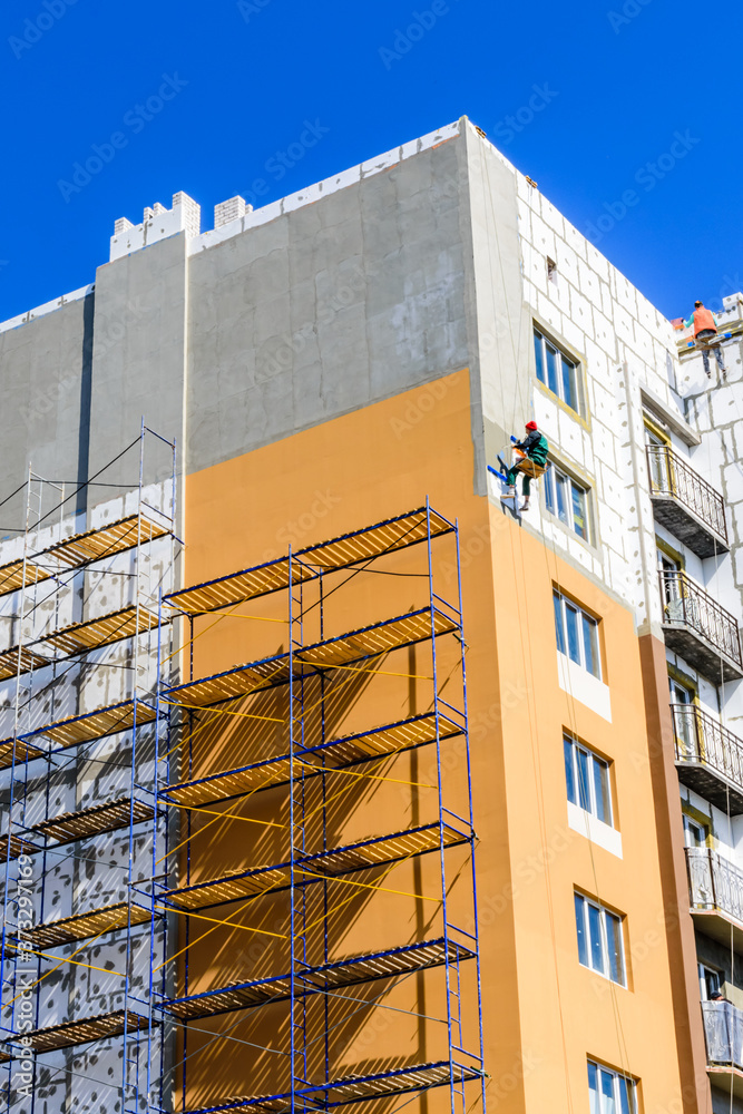 Insulation of the multistory residential building with styrofoam. Rope ...