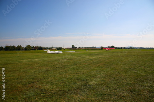 View of Glider being towed to take off at green airfield with blue sky in Germany