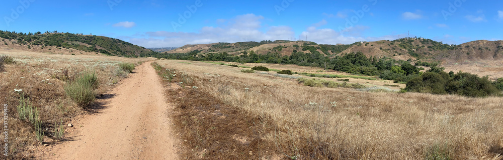 Panoramic view of dry dusty trails in the valley with blue sky, San Diego, California, USA