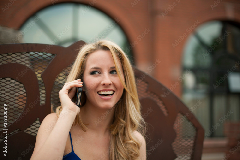 A beautiful woman laughing while talking on a cell phone A beautiful woman laughing while talking on a cell phone
