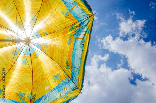 Yellow beach umbrella against sunlight.