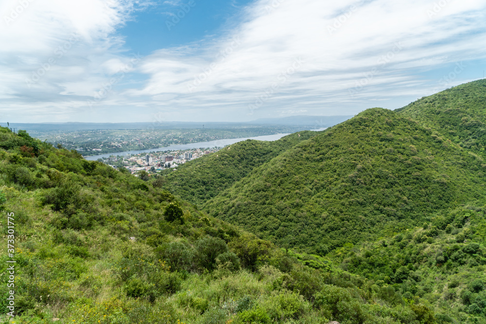 Montañas verdes tapando una ciudad.