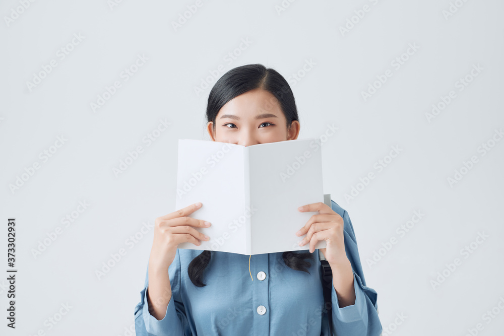 Happy pensive girl holding white notebook, covering half of face, looking attentively at camera, Happy pensive girl holding white notebook, covering half of face, looking attentively at camera,