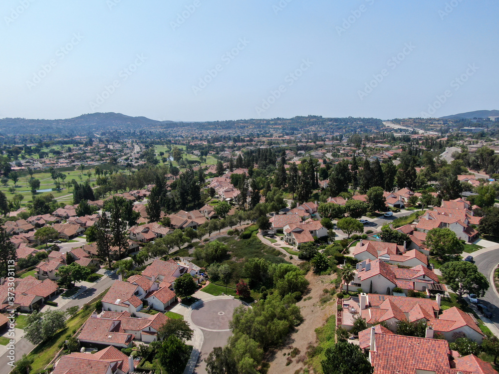 Aerial view of middle class neighborhood with residential house community and mountain on the background in Rancho Bernardo, South California, USA.