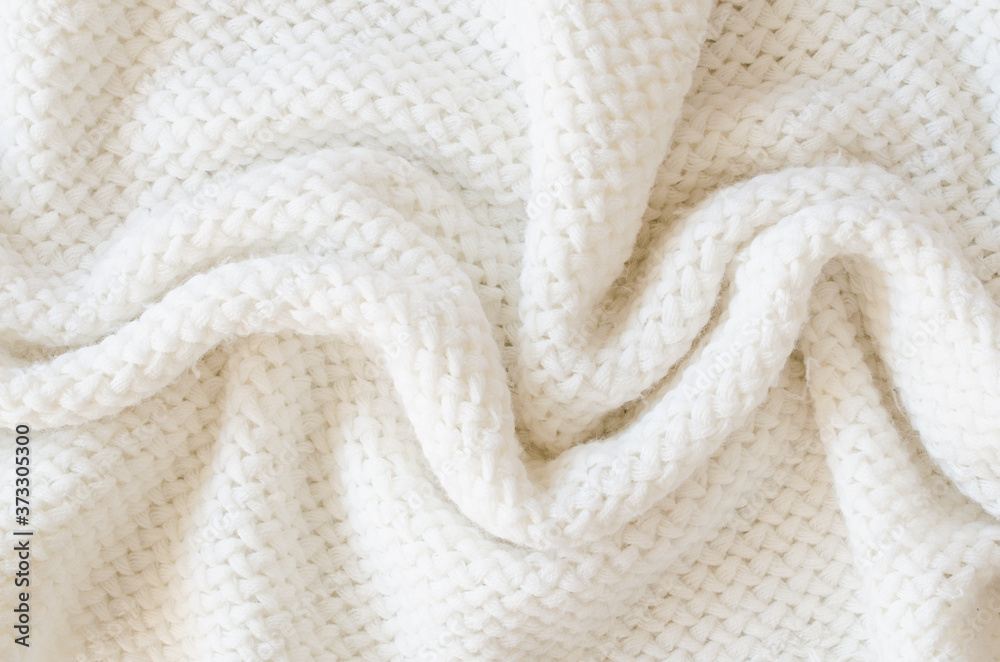 Beige knitted woolen background. Knitwear fabric texture. Beige knitted woolen background. Knitwear fabric texture.