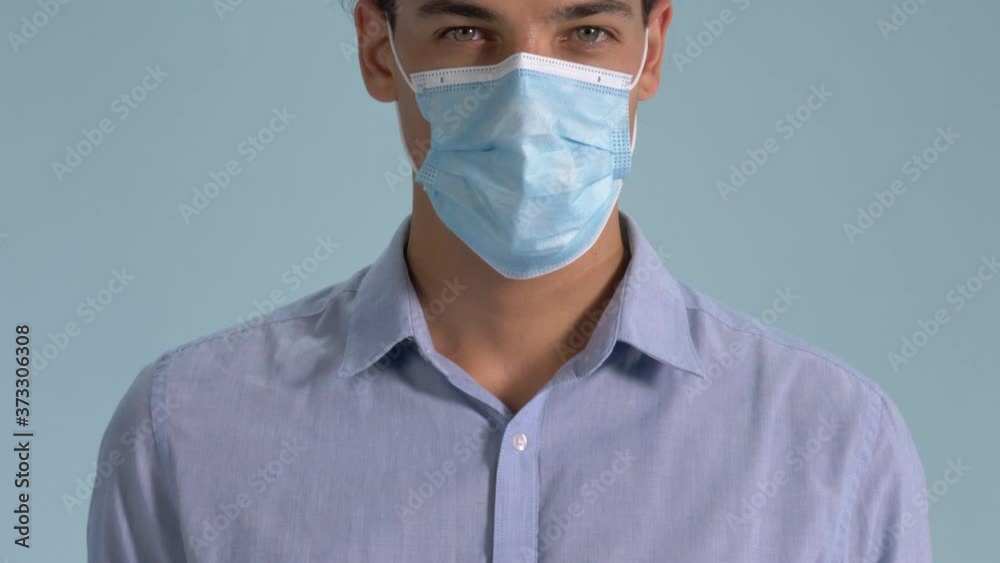 A Professional Looking Man Wearing His Surgical Face Mask Properly Standing On Blue Background - Coronavirus Outbreak - Closeup Shot A Professional Looking Man Wearing His Surgical Face Mask Properly Standing On Blue Background - Coronavirus Outbreak - Closeup Shot