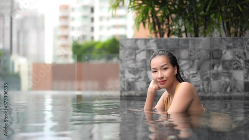 Fashion asian model swimsuit posing in a pool photo