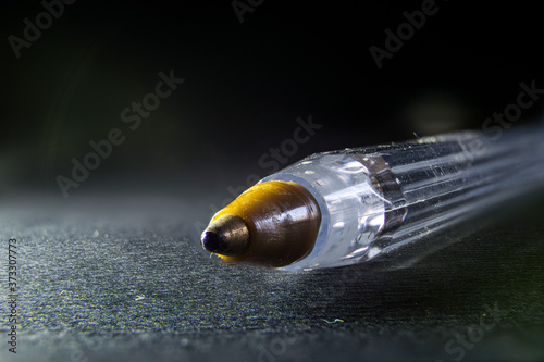 primo piano della punta a sfera di una penna bic, su sfondo nero photo