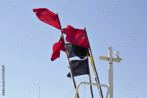 Red and black flags waving in the blue sky in Norre Vorupor Denmark photo