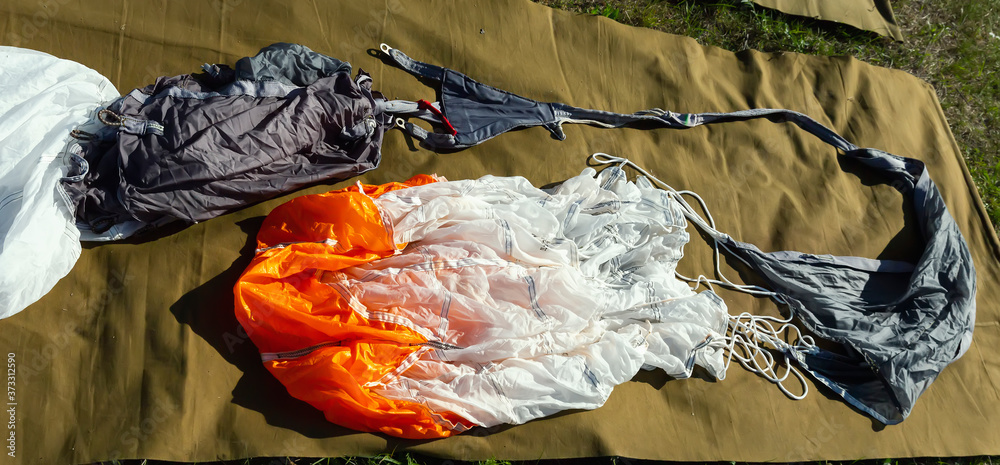 The parachute lies on the grass for assembly and further jump