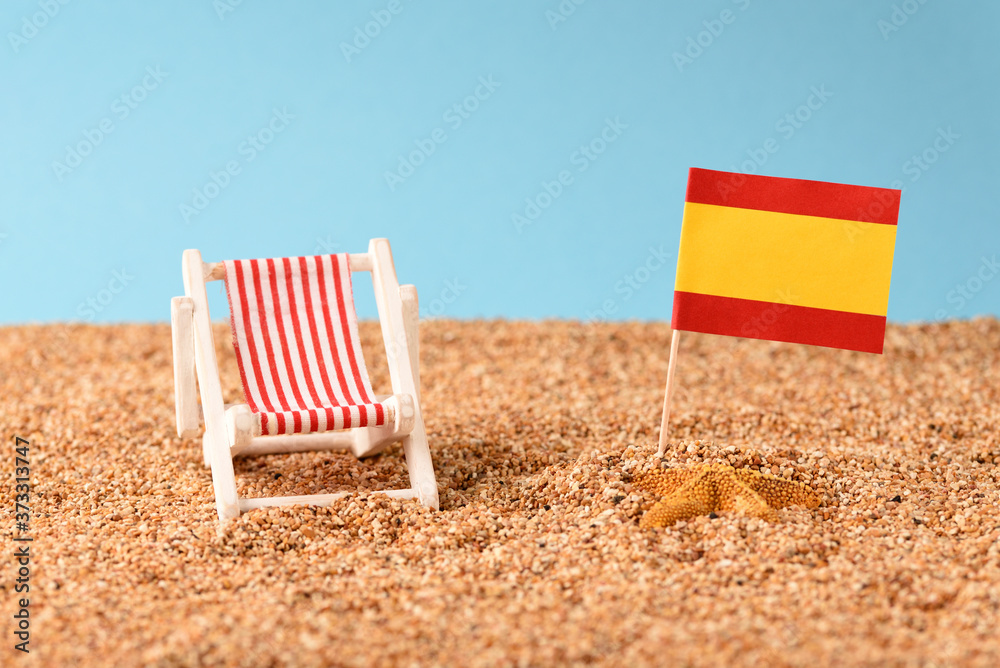 Spanish flag on the sandy seashore at the sunbed. Spanish flag on the sandy seashore at the sunbed.