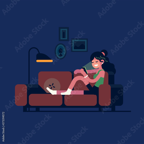 Cheerful adult young woman using her smartphone relaxing on couch at home late at night. Girl browsing mobile internet, spending free time on social media