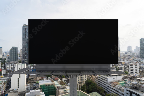 Blank black road billboard with Bangkok cityscape background at day time. Street advertising poster, mock up, 3D rendering. Front view. The concept of marketing communication to promote or sell idea.