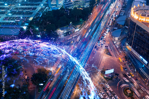 Fototapeta Naklejka Na Ścianę i Meble -  Abstract technology icons hologram on aerial top view of road, busy urban traffic highway at night. Junction network of transportation infrastructure. The concept of hi-tech in logistics.