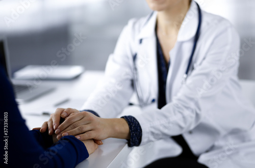 Unknown woman-doctor is reassuring her female patient, close-up. Physician is consulting and giving some advices to a woman. Concepts of medical ethics and trust. Empathy in medicine