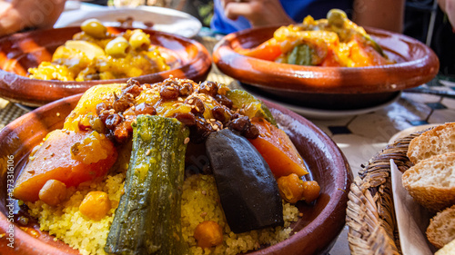 Couscous (Arabic: كُسْكُس‎ ) is a Maghrebi dish of small (about 3mm diameter) steamed balls of crushed durum wheat semolina, usually served with a stew spooned,vegetables at family gatherings.