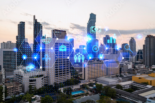 Hologram of Research and Development glowing icons. Sunset panoramic city view of Bangkok. Concept of innovative technologies to create new services and products in Asia. Double exposure.