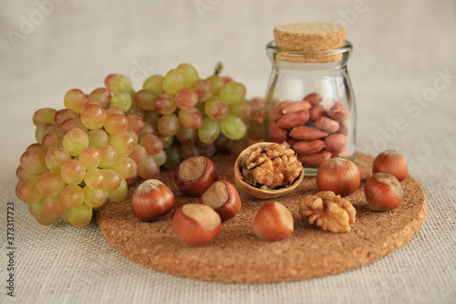 Still life of walnuts, hazelnuts, kishmish grapes. Healthy snack. HLS.