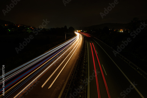 Red white blue car light trails on a road highway