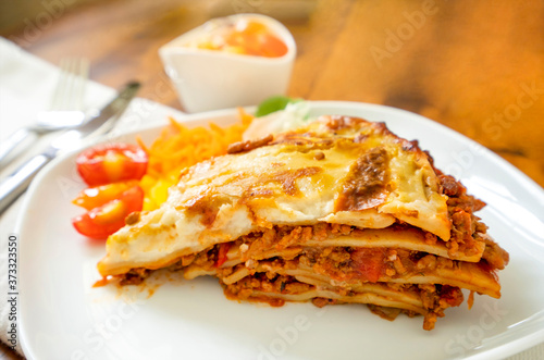 Delicious Traditional Italian Lasagna Bolognese with minced meat , tomato sauce and mixed salad, Homemade Italian meal