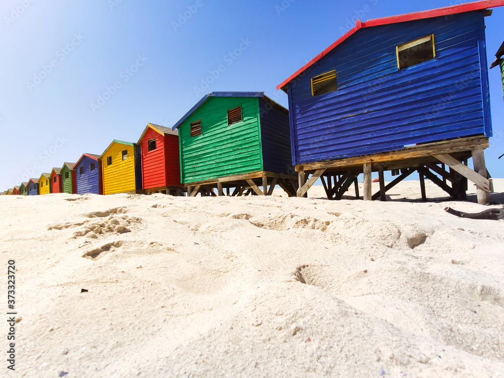 colorful beach houses on the beach at Muizenberg in side perspective