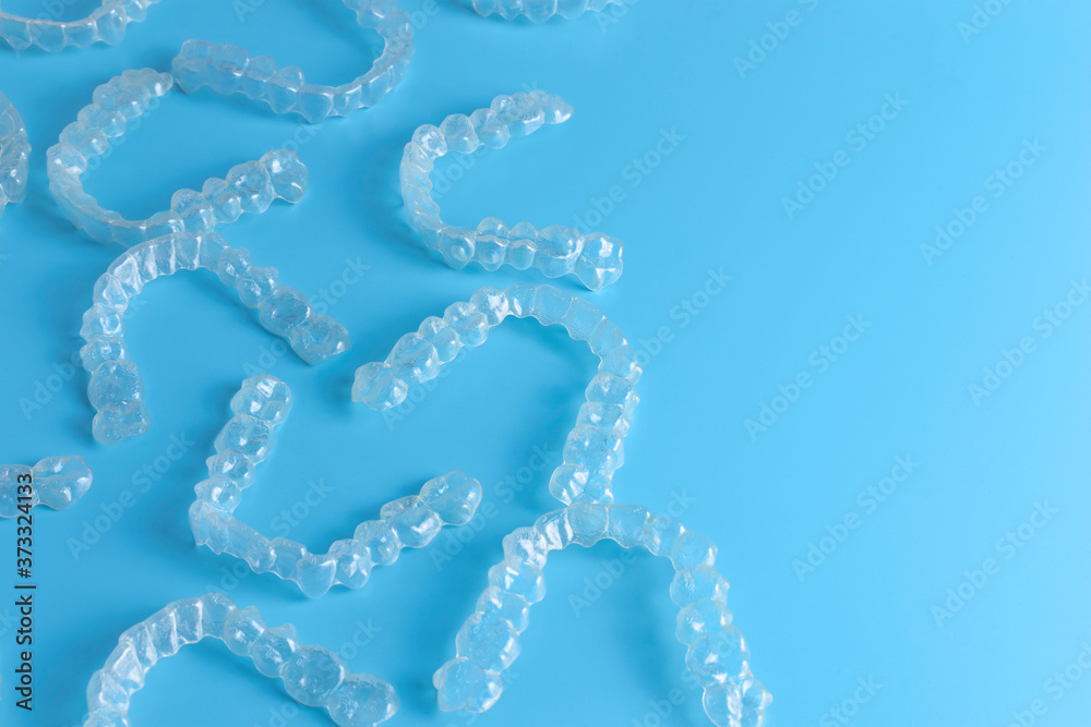 Invisalign transparent brackets or braces on blue background with copy space Invisalign transparent brackets or braces on blue background with copy space
