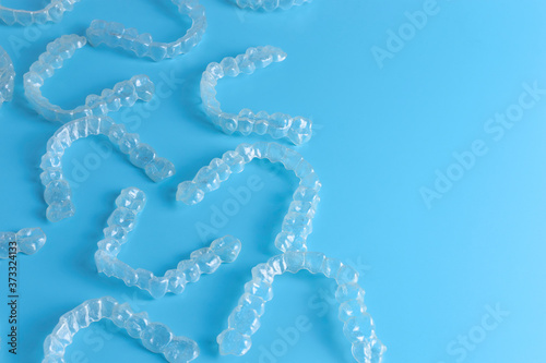 Invisalign transparent brackets or braces on blue background with copy space