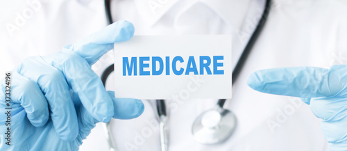 Doctor holds a sheet with the word MEDICARE  Medical concept