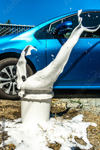 Soap Bucket Splashes When Scrubbing Brush Hits Water in Front of a Car about to be washed