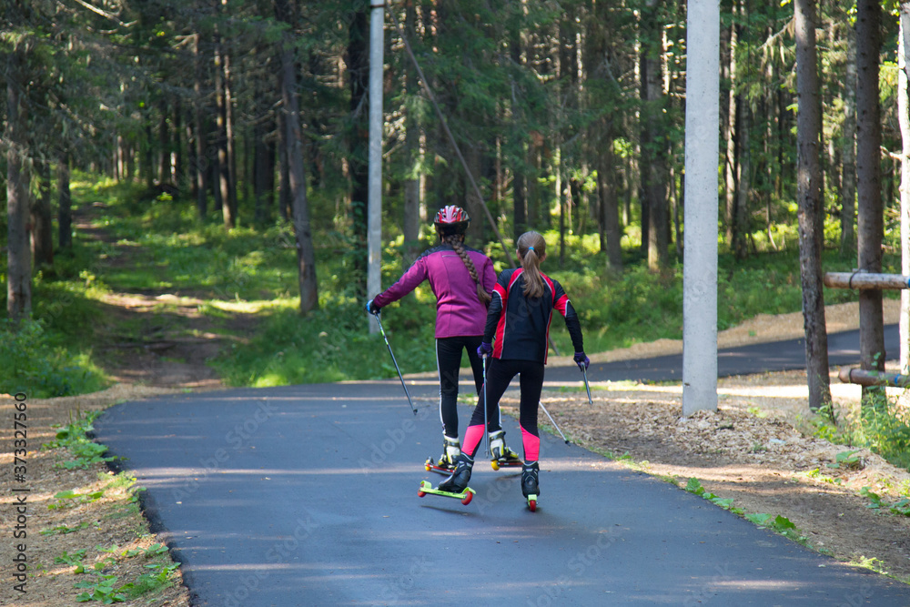 Fototapeta premium Woman cross-Country skiing with roller skis in the Park