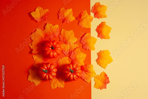 Fototapeta Naklejka Na Ścianę i Meble -  Orange composition made from bright fall leaves and pumpkins on the bright paper background