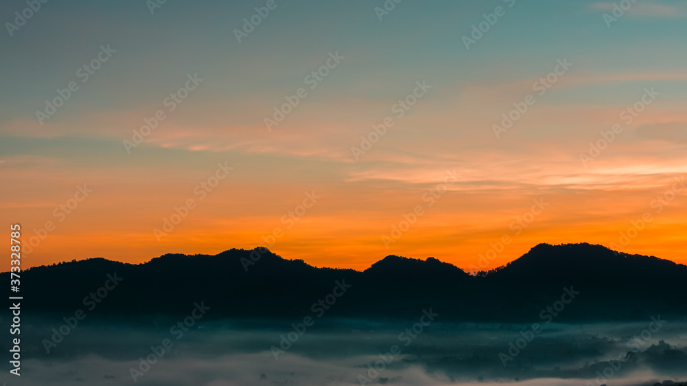 Sunrise on Lembang Valley Bandung. Orange Dawn Sky Morning behind Hills and Mountain.