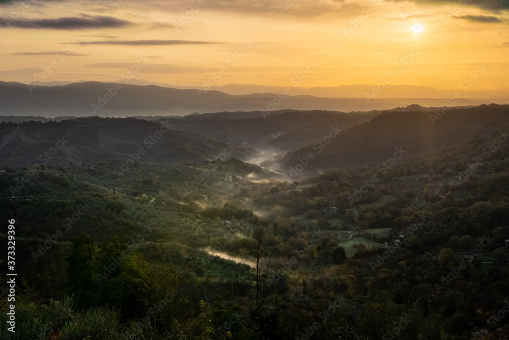 l'alba nella valle di civita di bagnoregio, con nebbia nel fondovalle l'alba nella valle di civita di bagnoregio, con nebbia nel fondovalle