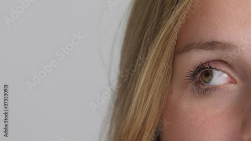 Attractive young blond caucasian woman puts on mascara with mascara brush in mirror close-up 4k 50fps