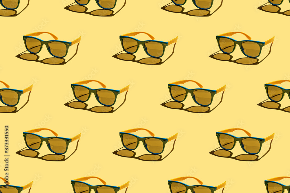 Multicolored sunglasses seamless pattern on pastel yellow background. Minimal summer concept. Trendy sunlight summer pattern. Multicolored sunglasses seamless pattern on pastel yellow background. Minimal summer concept. Trendy sunlight summer pattern.