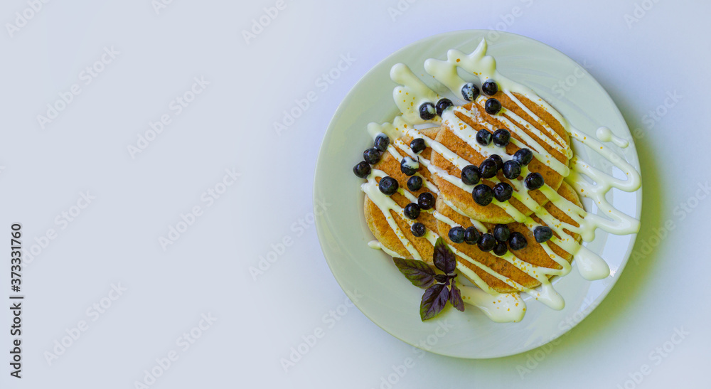 Pancakes with blueberries, sour cream and honey. Close-up top view. Selective focus.copyspace for text. Pancakes with blueberries, sour cream and honey. Close-up top view. Selective focus.copyspace for text.