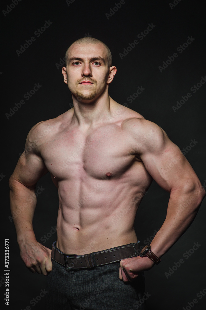 Sporty sexy man stands Topless on a dark background. Sports, beauty Sporty sexy man stands Topless on a dark background. Sports, beauty