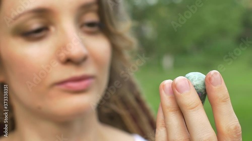 Portrait of a girl with dreadlocks hairstyle holding in hand little natural stone anyolite photo