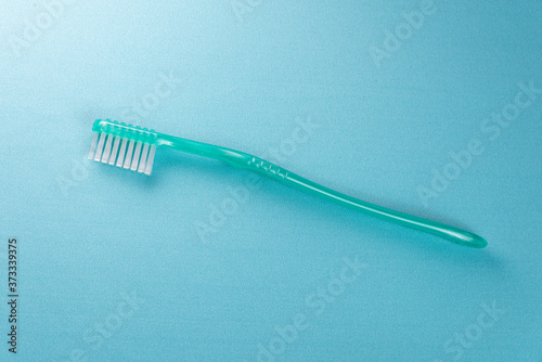 Green toothbrush on the blue background