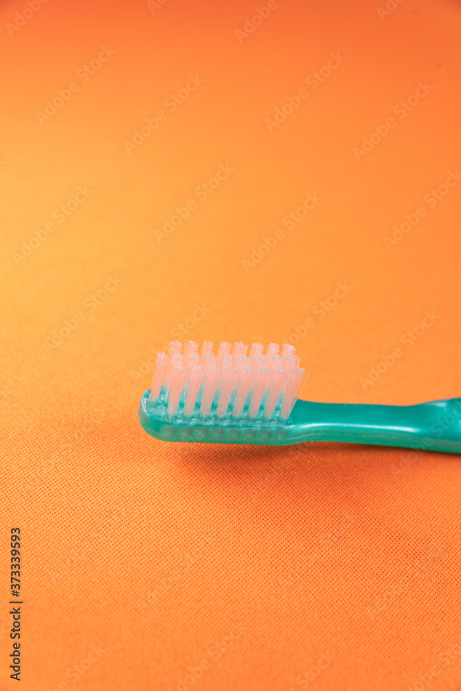 Green toothbrush on the orange background Green toothbrush on the orange background