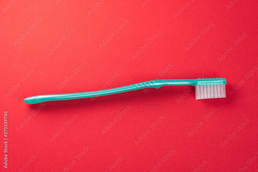 Green toothbrush on the red background Green toothbrush on the red background