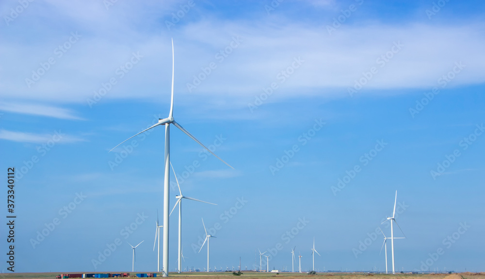Fototapeta premium Wind turbines are installed in the steppe on a background of blue sky