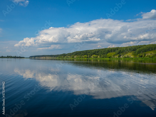 A wide river in Central Siberia. Clouds reflected in the water and beautiful shores.