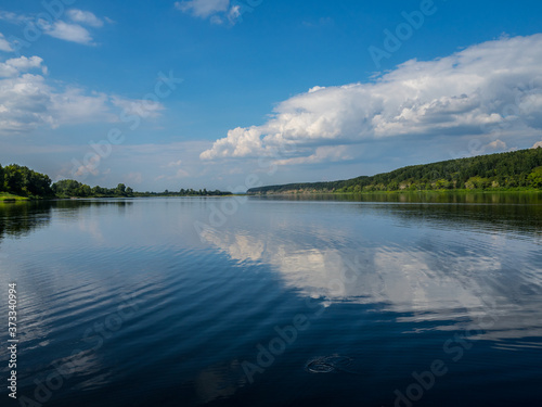A wide river in Central Siberia. Clouds reflected in the water and beautiful shores. © vitaly