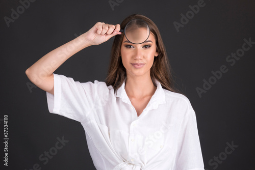 beautiful  young woman  commercial face type holding magnifier over her face beauty skin concept, 