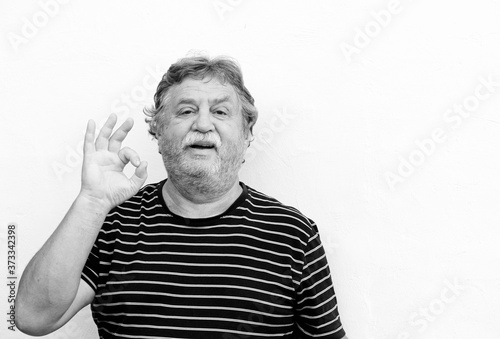 Black and white portrait of middle-aged man showing ok gesture with his right hand