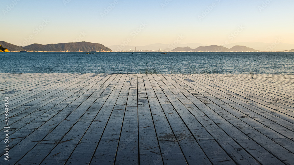 View towards the sea from the wooden deck on the shore of Naoshima Island, Japan.