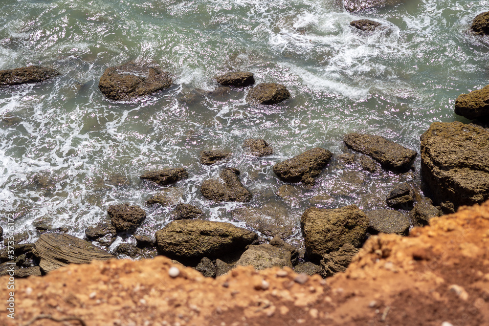 Obraz premium Vista desde un acantilado con las olas del mar golpeando las rocas