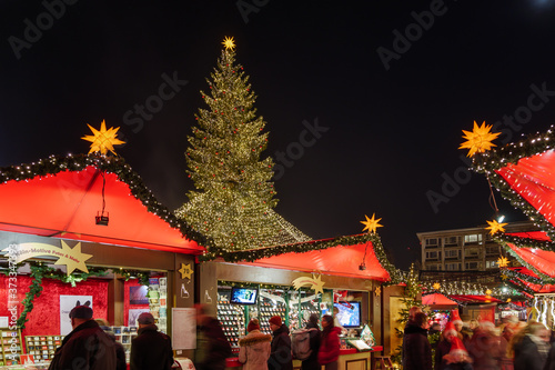 Night atmosphere of Weihnachtsmarkt  Christmas Market  with various decorated illuminate stalls surround  big Christmas tree at plaza in front of Cologne Cathedral in K  ln  Germany.
